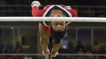 La norteamericana Gabrielle Douglas en plena competencia en barras asimétricas (AFP)