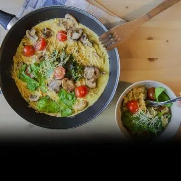 Una tortilla u omelette de harina de garbanzo. En este caso está rellena de espinaca y champiñones.