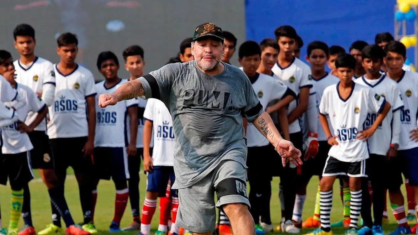 Diego Maradona patea la pelota ante la atenta mirada de los atentos estudiantes que asistieron a su clínica de fútbol.